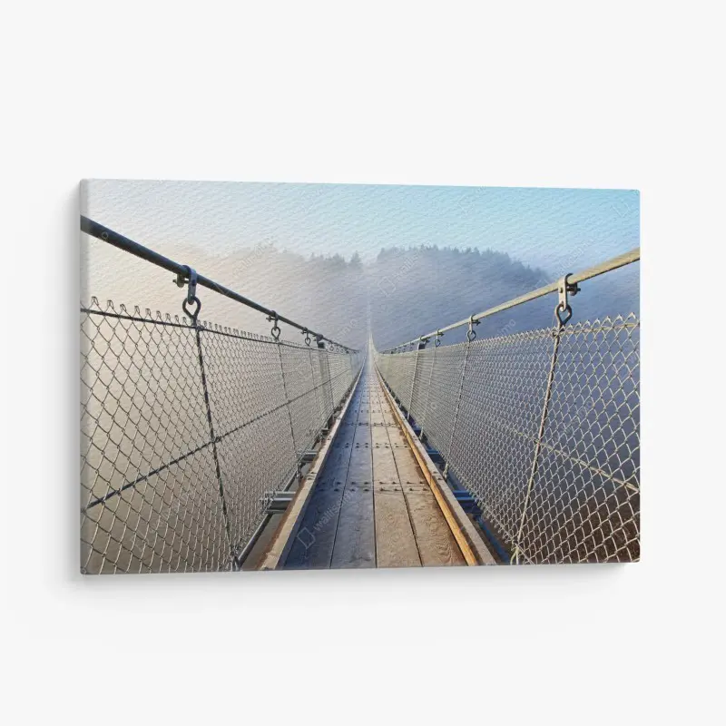 Leinwandbild neblige hängebrücke, die in den wald führt