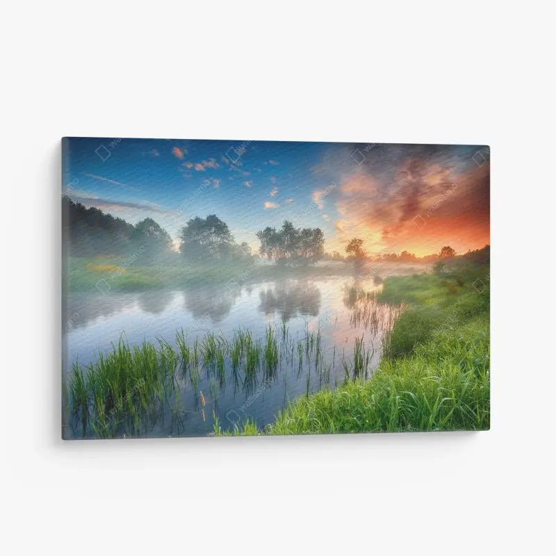 Leinwandbild nebliger fluss bei sonnenaufgang über grünen ufern