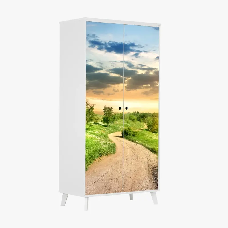 Schrankaufkleber sonnenuntergang über einem feldweg durch grüne wiese