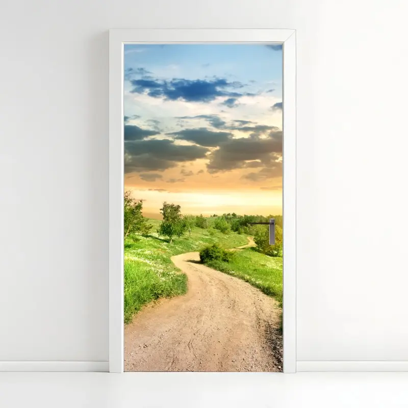 Türaufkleber sonnenuntergang über einem feldweg durch grüne wiese