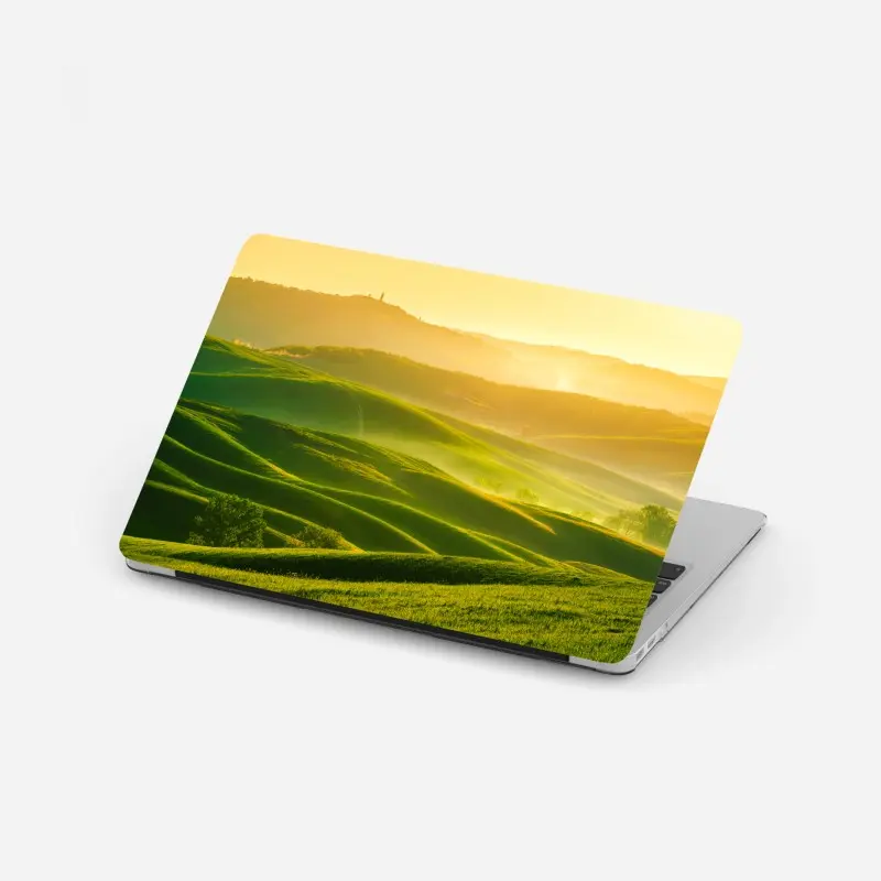 Laptop-Aufkleber goldener sonnenaufgang über sanften grünen hügeln