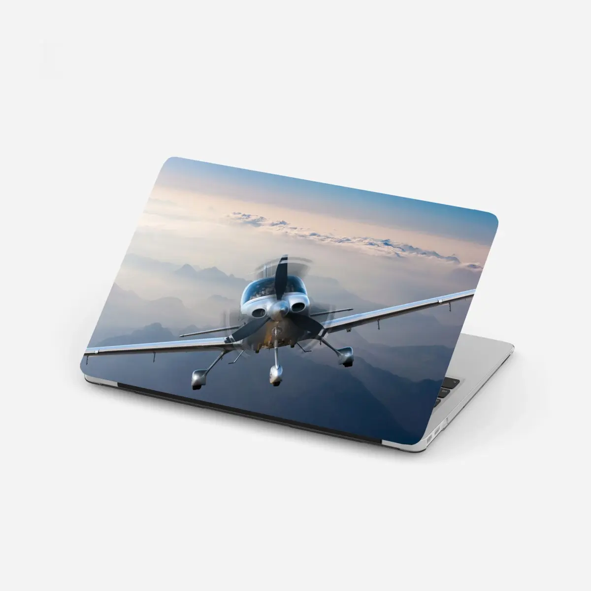 Laptop-Aufkleber silbernes propellerflugzeug über nebeligen bergen – Pixers®