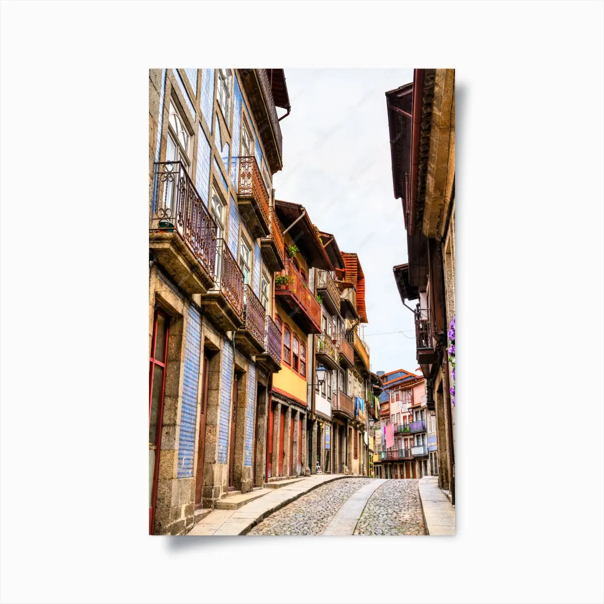 Poster malerische gepflasterte straße mit bunten fassaden – Pixers®