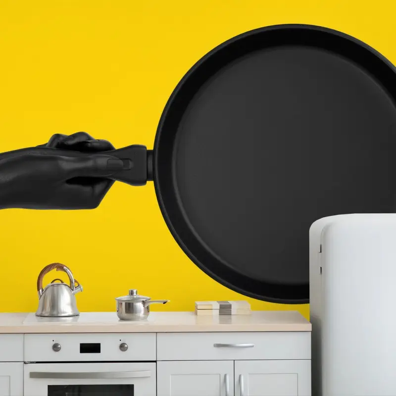 Fototapete schwarze pfanne auf leuchtend gelbem hintergrund